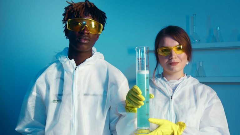 Two scientists in protective gear conducting experiments in a lab setting.